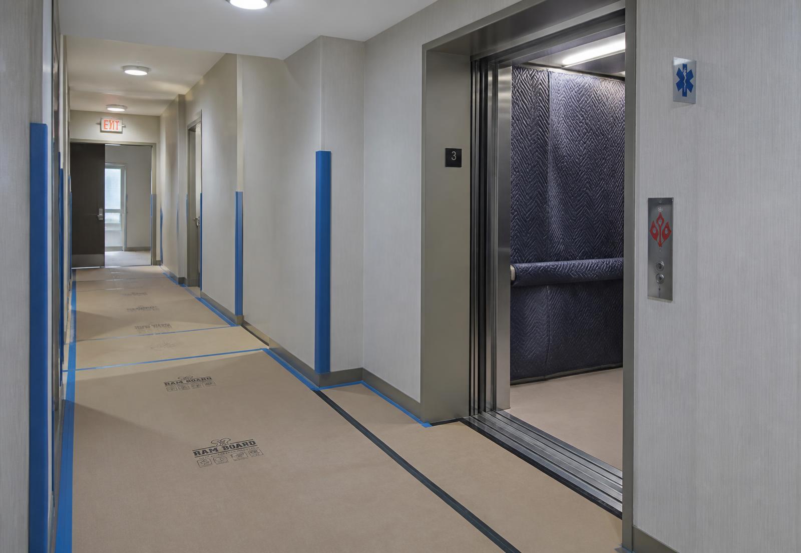 Condominium corridor with floor protection and padded freight elevator